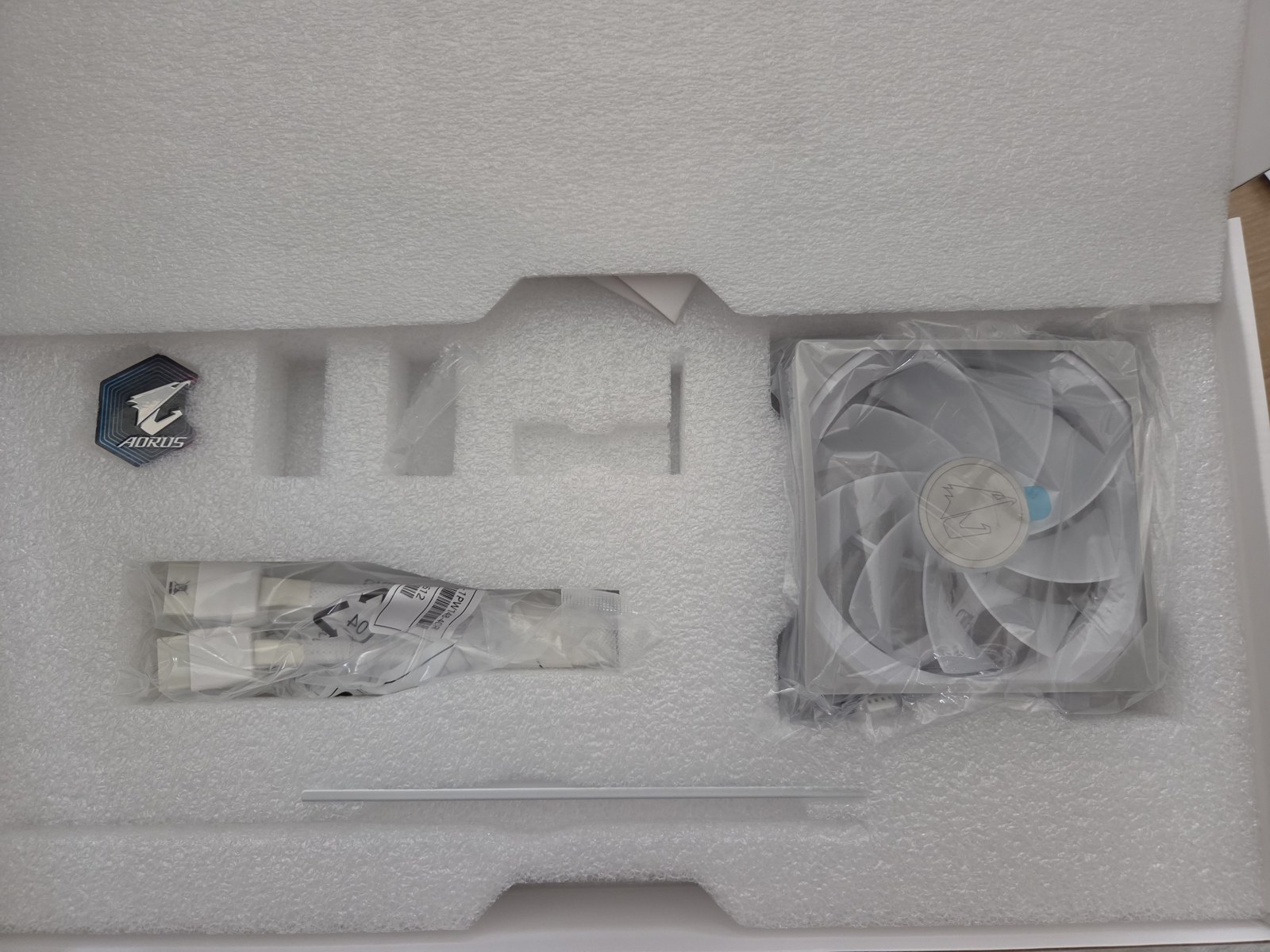 Box contents - a spare fan, a support bracket, a sticker, and screws